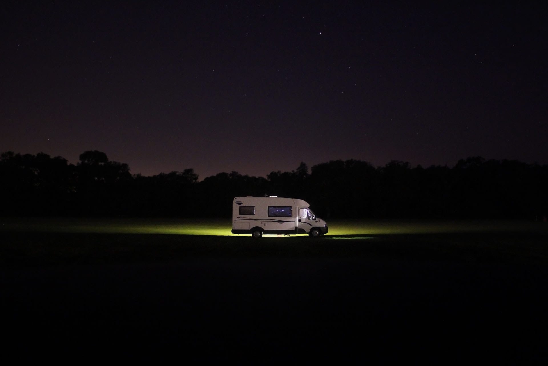 motorhome-lit-up-in-field-at-night-essential-motorhome-accessories